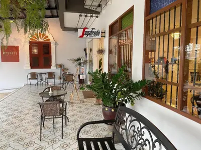 a restaurant with a table and chairs in a building at Mystays Phuket in Phuket Town