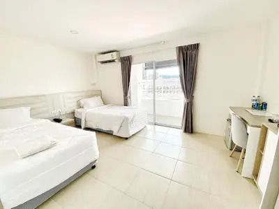 a hotel room with two beds and a window at Mystays Phuket in Phuket Town