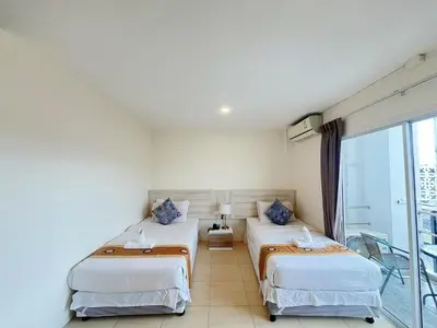 a hotel room with two beds and a balcony at Mystays Phuket in Phuket Town