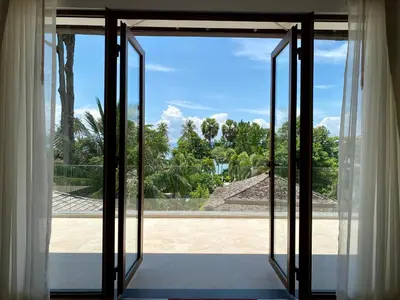 an open glass door with a view of a yard at Villa Tango Victoria Resort, Koh Yao Noi in Ko Yao Noi
