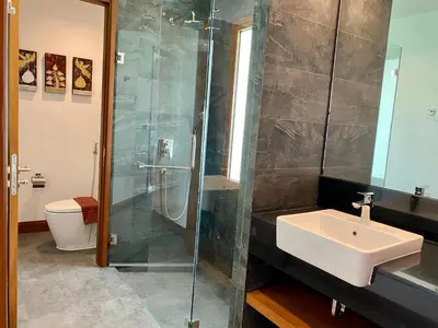 a bathroom with a sink and a glass shower at Villa Tango Victoria Resort, Koh Yao Noi in Ko Yao Noi