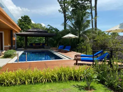 a backyard with a pool and chairs and a gazebo at Villa Tango Victoria Resort, Koh Yao Noi in Ko Yao Noi