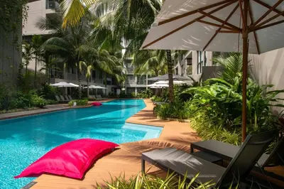 a swimming pool with chairs and an umbrella at Diamond CONDO by VС in Bang Tao Beach