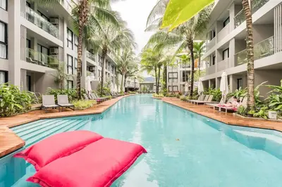 a swimming pool in a hotel with palm trees at Diamond CONDO by VС in Bang Tao Beach
