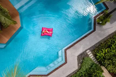 an overhead view of a pool with a pink chair in the water at Diamond CONDO by VС in Bang Tao Beach