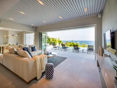 a living room with a couch and a view of the ocean at Villa Borimas by Elite Havens in Surin Beach