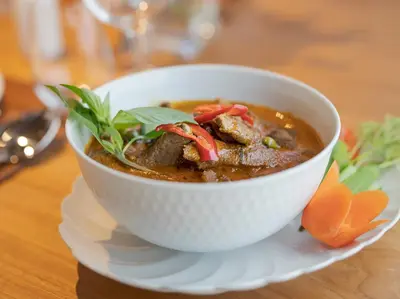 a bowl of soup on a plate on a table at Luxury Beachfront Villa Phuket Private Pool Full Staff At Natai Beach in Natai Beach