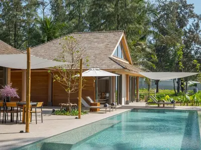 a house with a swimming pool and umbrellas at Luxury Beachfront Villa Phuket Private Pool Full Staff At Natai Beach in Natai Beach