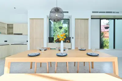 a wooden table in a kitchen with a dining room at Chomdao Maikhao in Mai Khao Beach