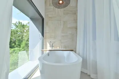 a bathroom with a large white tub in front of a window at Chomdao Maikhao in Mai Khao Beach