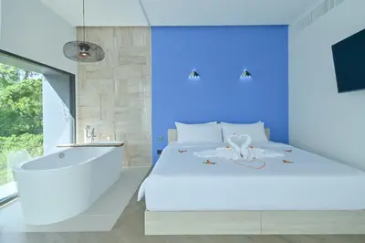 a bedroom with a white bed and a bath tub at Chomdao Maikhao in Mai Khao Beach