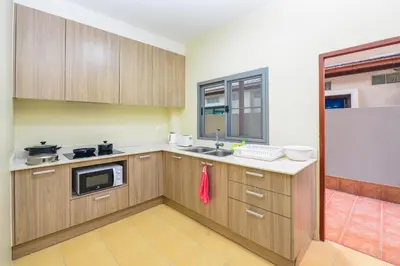 a kitchen with wooden cabinets and a microwave at 74 Patong villa walk to Bangla Rd in 10min 3 room cozy modern style in Patong Beach