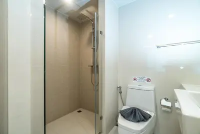 a bathroom with a shower and a toilet and a sink at Aristo Resort Surin Beach S03 in Surin Beach