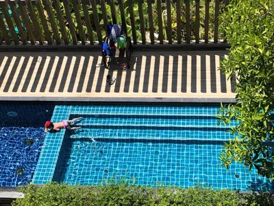 a person is swimming in a swimming pool at Aristo Resort Surin Beach S03 in Surin Beach