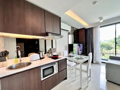 a kitchen with a sink and a table in a room at Aristo Resort Surin Beach S03 in Surin Beach