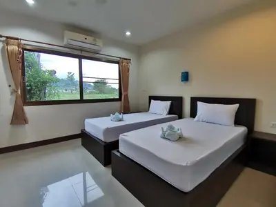 two beds in a room with a window at Nestvilla Khok-kloi Phang-nga in Ban Nai