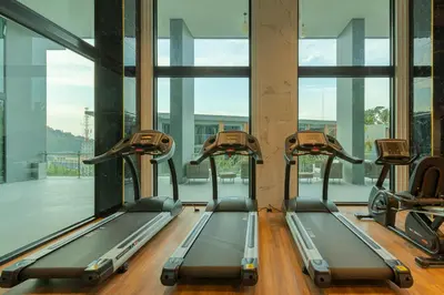 a row of treadmills in a gym with windows at Sea View 1-BR 36 m2 Panora Surin by Holy Cow in Surin Beach