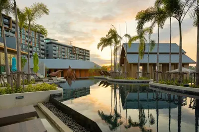 a pool at a resort with palm trees and a building at Sea View 1-BR 36 m2 Panora Surin by Holy Cow in Surin Beach