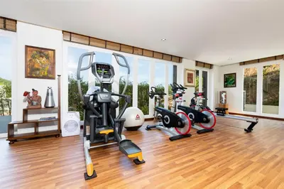 a gym with exercise equipment in a room with wood floors at SAMSAM Yao Noi - ANDAMAN MAGIC & ART VILLAS in Ko Yao Noi