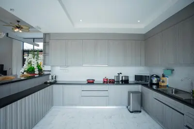 a large kitchen with white cabinets and a sink at Gold Chariot Pool Villa, Phuket - SHA Plus Certified in Bang Tao Beach