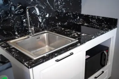 a kitchen sink with a black counter top at 1BDR Apartment near Surin beach #210 in Surin Beach