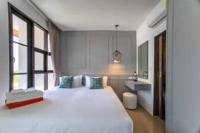 a bedroom with a large white bed and windows at 2BDR Apartment near Surin beach PALM-C703 in Surin Beach