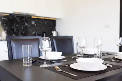 a table with plates and glasses on top of it at 2BDR Apartment near Surin beach PALM-C703 in Surin Beach