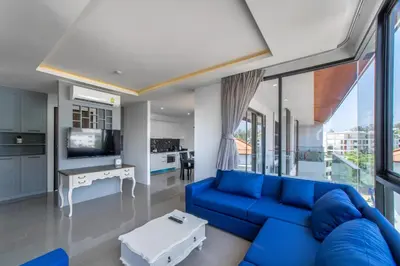 a living room with a blue couch and a tv at 2BDR Apartment near Surin beach PALM-C703 in Surin Beach