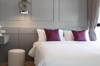 a bedroom with a white bed with purple pillows at 2BDR Apartment near Surin beach PALM-C703 in Surin Beach