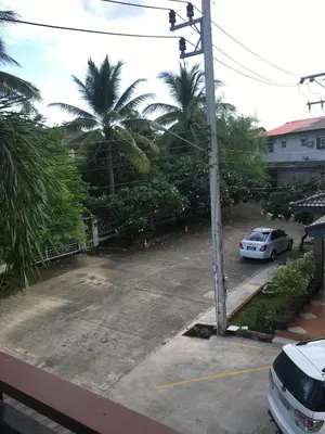 a car parked in a parking lot with palm trees at Nasa Hotel in Phuket Town