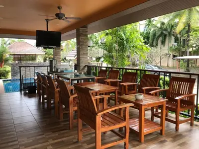 a restaurant with wooden tables and chairs on a balcony at Nasa Hotel in Phuket Town