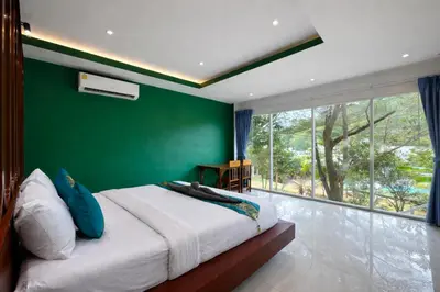 a bedroom with a green wall and a large bed at Phi Phi Chang Grand Resort in Phi Phi Don