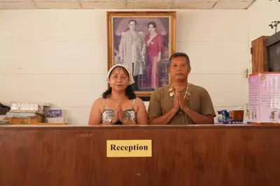 a man and a woman standing behind a desk at Phi Phi Chang Grand Resort in Phi Phi Don