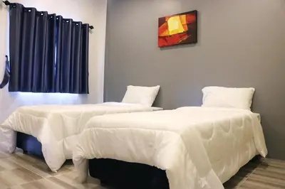 two beds in a room with white sheets at N&N HOUSE Laem Hin in Ban Laem Hin