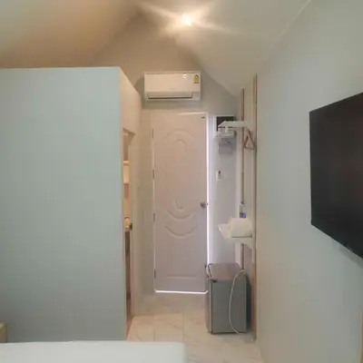 a small room with a white door and a television at N&N HOUSE Laem Hin in Ban Laem Hin