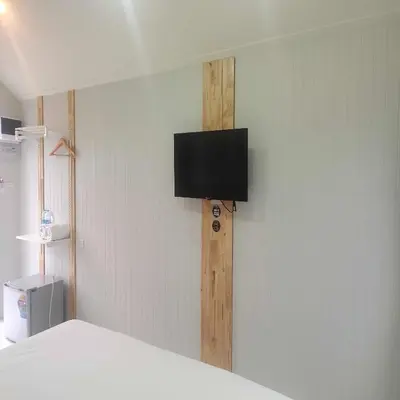 a flat screen tv on the wall of a room at N&N HOUSE Laem Hin in Ban Laem Hin