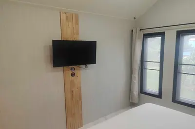 a room with a flat screen tv on the wall at N&N HOUSE Laem Hin in Ban Laem Hin