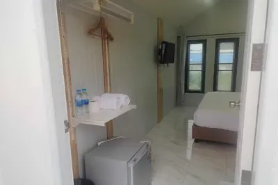 a small room with a bed and a small refrigerator at N&N HOUSE Laem Hin in Ban Laem Hin