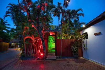 an entrance to a house with a tree with red lights at Villa Paradise Island in Rawai Beach