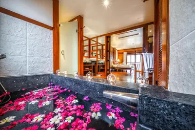 a bathtub filled with pink flowers in a room at Baan Yin Dee Boutique Resort Phuket - SHA Plus in Patong Beach