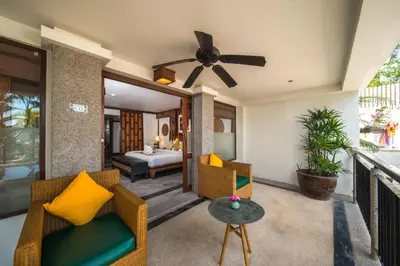 a living room with a ceiling fan and a bedroom at Baan Yin Dee Boutique Resort Phuket - SHA Plus in Patong Beach