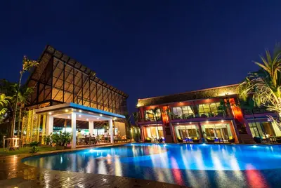 a building with a swimming pool at night at Mai Morn Resort SHA Plus in Phuket Town