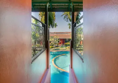 a view of a swimming pool from the window of a house at Mai Morn Resort SHA Plus in Phuket Town
