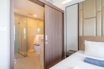 a bedroom with a bed and a shower and a toilet at Panora sea view -modern facilities walk to beach in Surin Beach