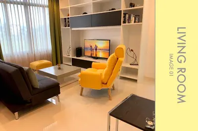 a living room with a yellow chair and a table at Stylish Condo w. Pool View 2F in Kamala Beach