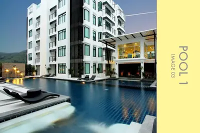 a hotel with a swimming pool in front of a building at Stylish Condo w. Pool View 2F in Kamala Beach