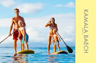 a man and a woman and two children on surfboards in the water at Stylish Condo w. Pool View 2F in Kamala Beach