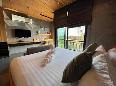 a bedroom with a large bed with a large window at Relife The Windy by VillaCarte in Rawai Beach