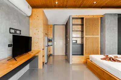 a bedroom with a bed and a flat screen tv at Relife The Windy by VillaCarte in Rawai Beach