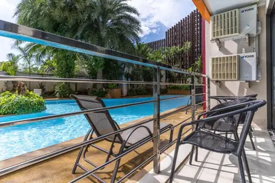 a balcony with two chairs and a swimming pool at Mai Khao Beach Condo by VillaCarte in Mai Khao Beach